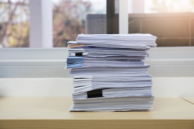 Mucchio di documenti non finiti sulla scrivania in ufficio, pila di business paper