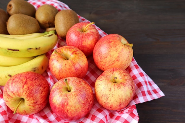 Mucchio di frutta fresca matura assortita su stoffa a scacchi per il concetto di MANGIARE BENE