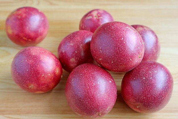 Mucchio di frutti della passione maturi freschi su fondo in legno