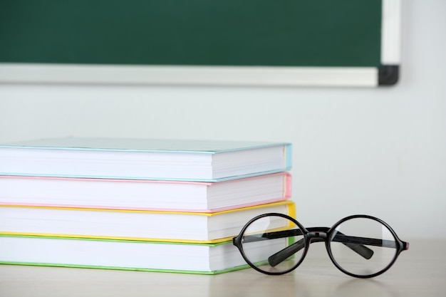 Mucchio di libri e bicchieri sul tavolo in classe