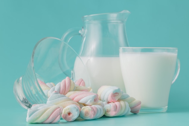 Mucchio di marshmallow colorati intrecciati con un bicchiere di latte