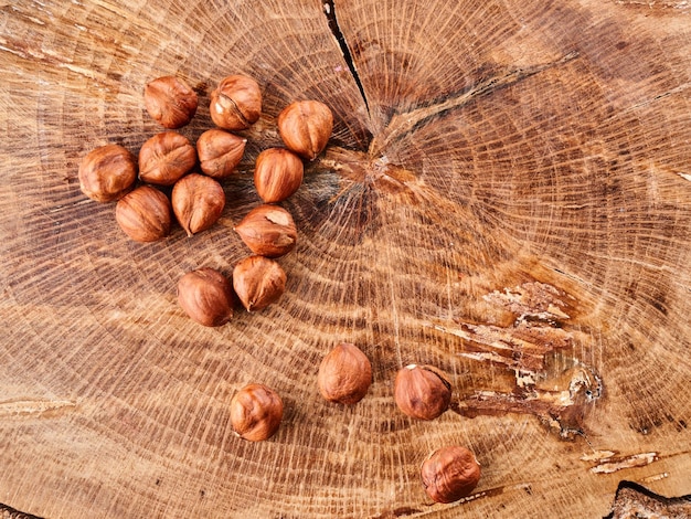 Mucchio di nocciole in guscio isolato su fondo di legno