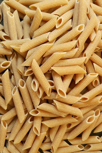 Mucchio di pasta di penne rigate di grano intero essiccato crudo