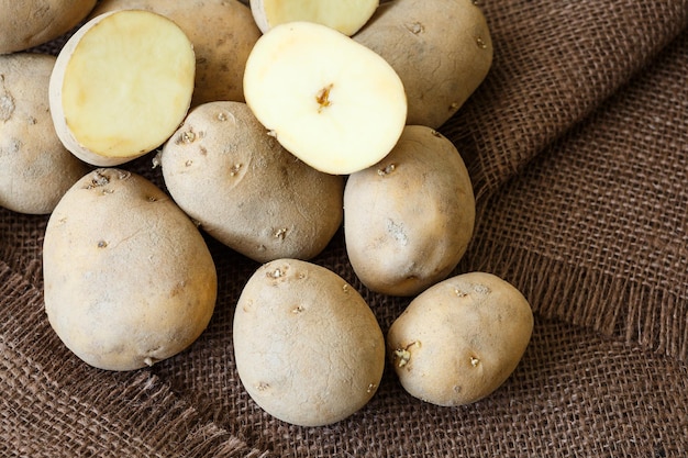 Mucchio di patate vecchie con germogli su sfondo marrone