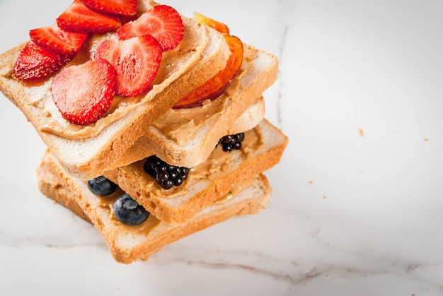 Mucchio di sandwich di frutta con burro di arachidi