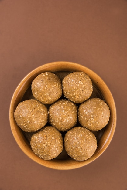 Mucchio di Tilgul Laddu o Til Gul Laddoo fatto a mano composto da jaggery o gud e semi di sesamo per il festival di Makar Sankranti, servito in una ciotola. messa a fuoco selezionata