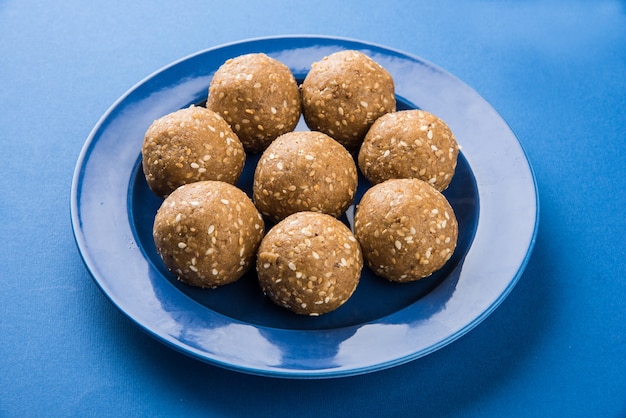 Mucchio di Tilgul Laddu o Til Gul Laddoo fatto a mano composto da jaggery o gud e semi di sesamo per il festival di Makar Sankranti, servito in una ciotola. messa a fuoco selezionata