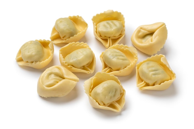 Mucchio di tortellini italiani freschi tradizionali ripieni di ricotta e spinaci su sfondo bianco