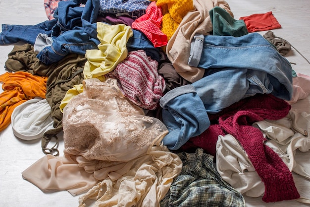 Mucchio di vestiti usati su uno sfondo chiaro Di seconda mano per il riciclaggio