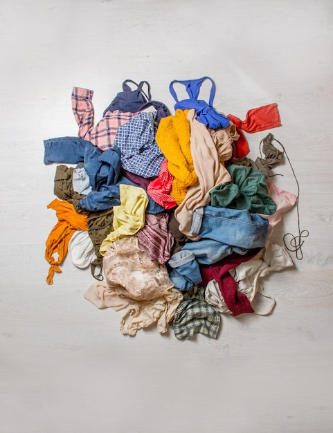 Mucchio di vestiti usati su uno sfondo chiaro Di seconda mano per il riciclaggio