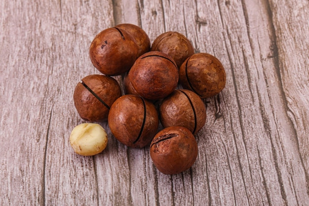 Mucchio marrone della noce di macadamia del primo piano sopra priorità bassa