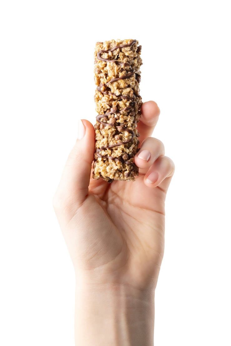 Foto muesli bar in mano isolato su sfondo bianco