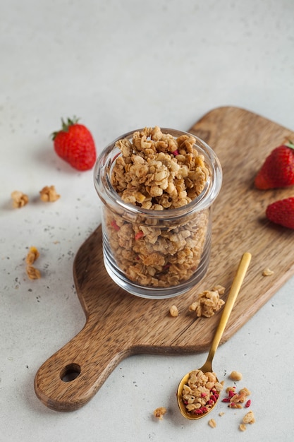 Muesli casalingo in un barattolo di vetro con fragole fresche. Il concetto di una colazione veloce, una dieta sana. Copia spazio.