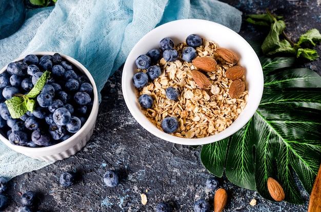 Muesli con mirtilli nel piatto bianco e tazza di tè per colazione,