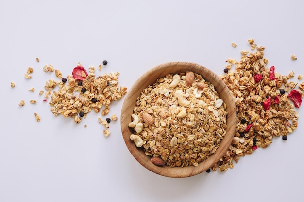 Muesli con noci e mandorle su sfondo bianco cereali sparsi