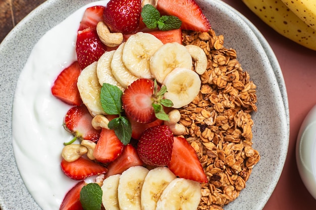 Muesli con yogurt alla fragola e banana in una ciotola