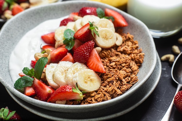 Muesli con yogurt alla fragola e banana in una ciotola