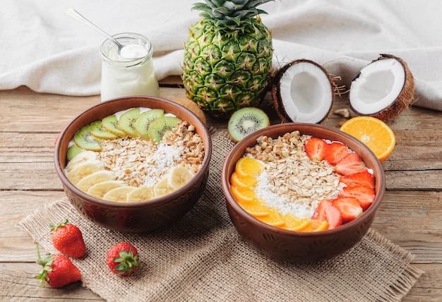 Muesli con yogurt greco e frutta su fondo di legno in stile rustico