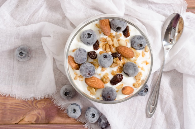 Muesli con yogurt naturale, mirtillo, frutta secca e frutta secca in un barattolo di vetro