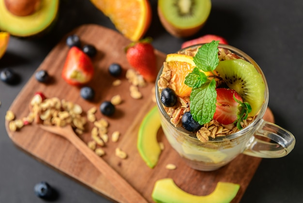 Muesli e yogurt e frutta sulla guarnizione in vetro