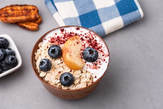 Muesli, farina d'avena con latte, pesca e bacche blu