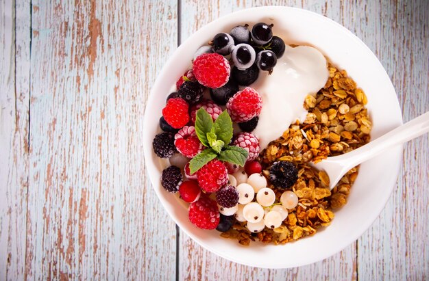 Muesli muesli cereali con yogurt o latte e frutti di bosco freschi Concetto di colazione sana