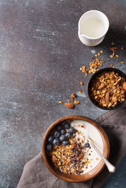 Muesli muesli fatto in casa con mirtilli su grigio scuro, vista dall'alto verticale