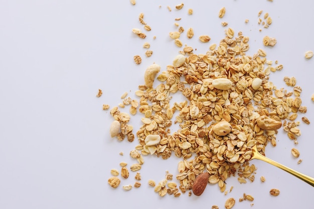 Muesli su cucchiaio isolato su sfondo bianco spazio copia Spuntino sano o concetto di colazione muesli fatti in casa con cereali e noci