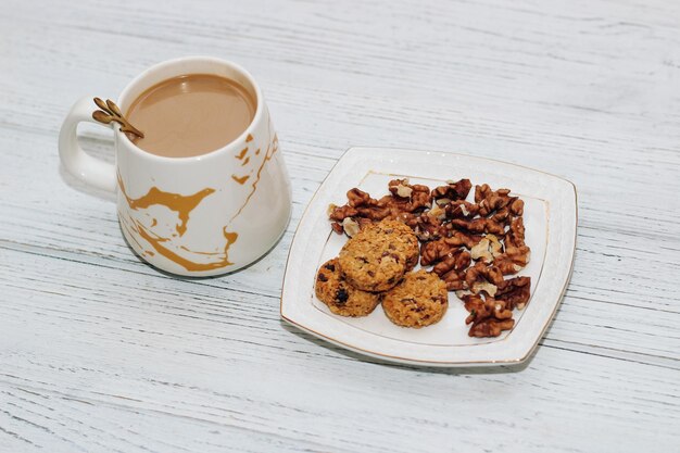 Muesli tondo di avena sana colazione con noci su un piatto e biscotti di semi di caffè