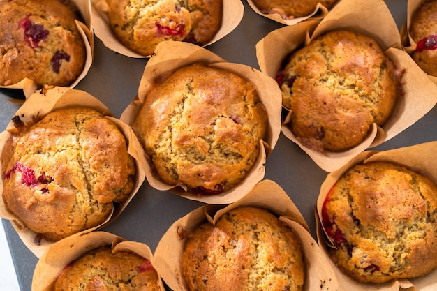 Muffin ai mirtilli rossi appena sfornati in pirottini di carta marrone.