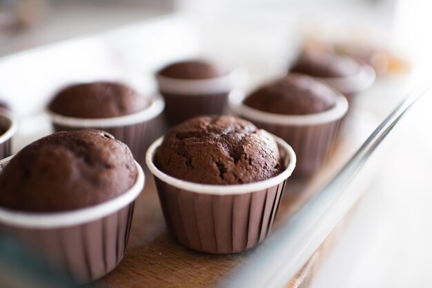Muffin al cioccolato appena sfornati in forme al tavolo della cucina si chiuda. Mangiare sano. Cucinare a casa.