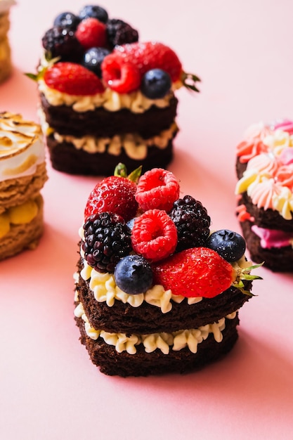 Muffin al cioccolato con fragole e more cibo dolce isolato su sfondo rosa. Cibo.