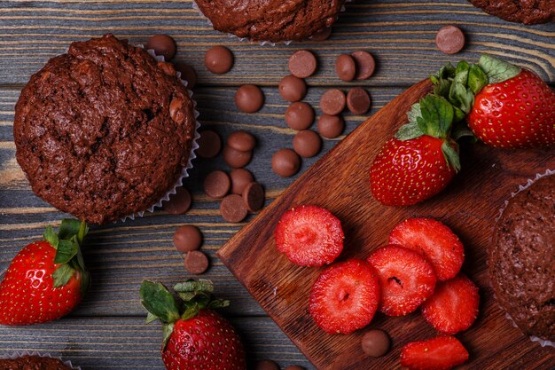 Muffin al cioccolato con fragole su oscurità.