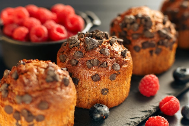 Muffin al cioccolato con frutti di bosco Cupcakes appetitosi su sfondo scuro