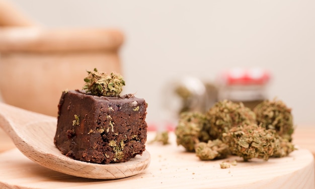 Muffin al cioccolato con germogli di cannabis su cucchiaio di legno Marijuana canapa negli alimenti
