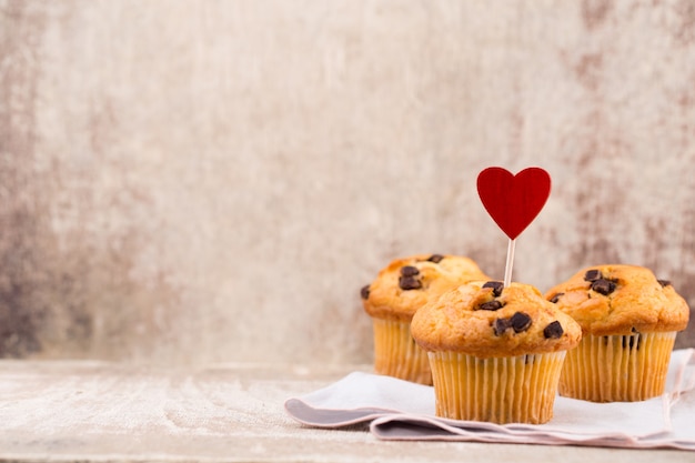 Muffin al cioccolato con sfondo vintage cuore, fuoco selettivo.