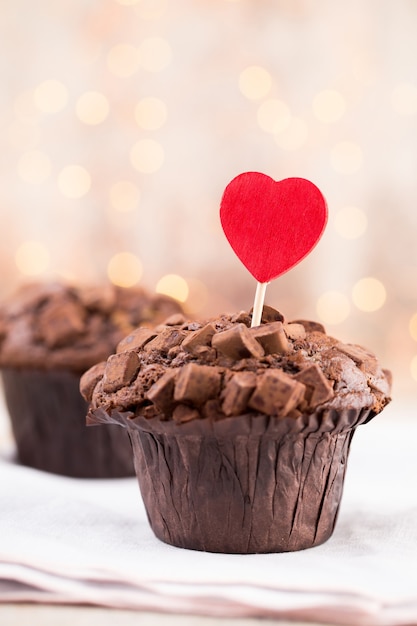 Muffin al cioccolato con superficie vintage cuore, fuoco selettivo.