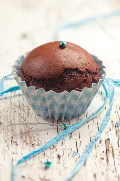 Muffin al cioccolato con una decorazione a nastro blu