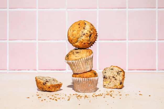 Muffin al cioccolato e banana in pila sparata su sfondo colorato luce dura orizzontale