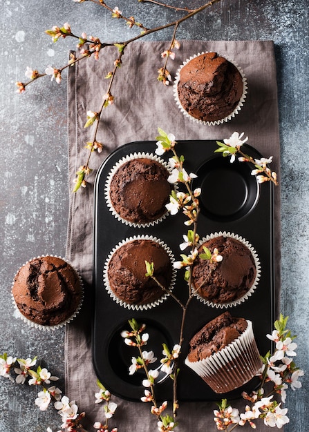 Muffin al cioccolato e cacao piatto con fiori rami concetto festa della mamma o del papà