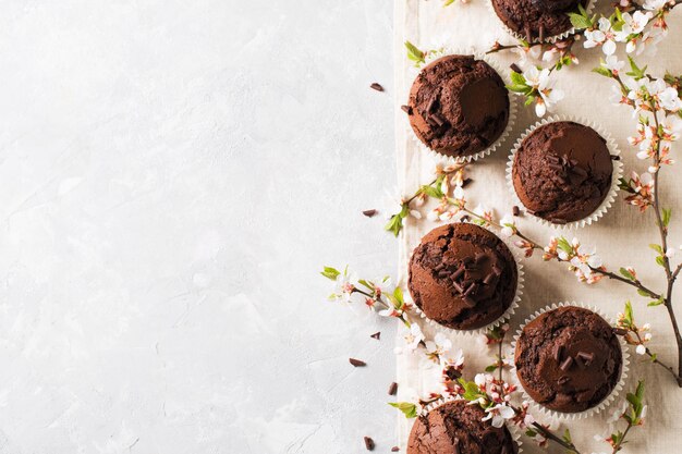 Muffin al cioccolato e cacao piatto con fiori rami concetto festa della mamma