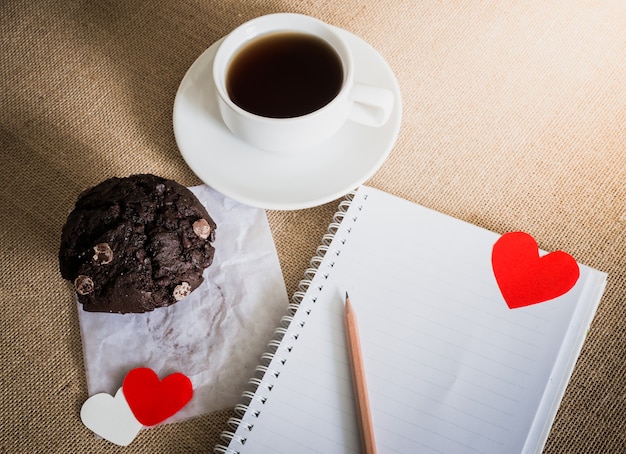 Muffin al cioccolato e caffè e cuori su trame di sacco