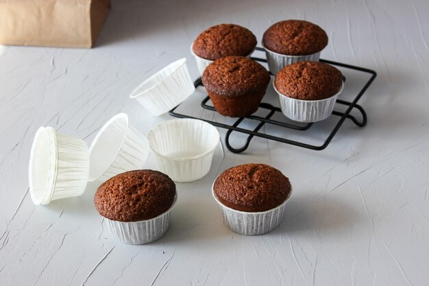 Muffin al cioccolato in carta su una superficie grigia