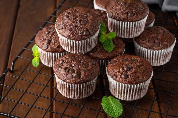 Muffin al cioccolato o cupcakes con gocce di cioccolato con frutti di bosco freschi e menta Copia spazio