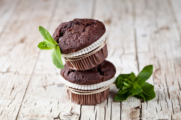 Muffin al cioccolato scuro con foglie di menta.