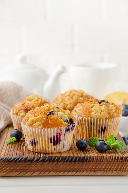 Muffin al limone con mirtilli e shtreisel con frutti di bosco freschi su uno sfondo di legno bianco