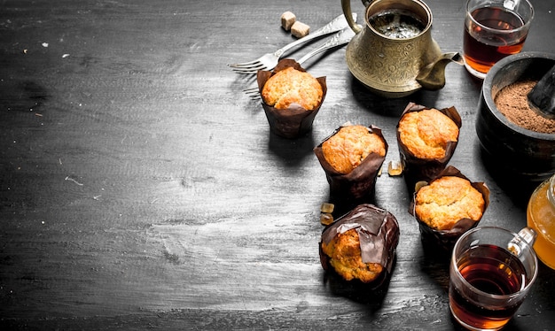 Muffin alla frutta con tè profumato sulla lavagna nera.