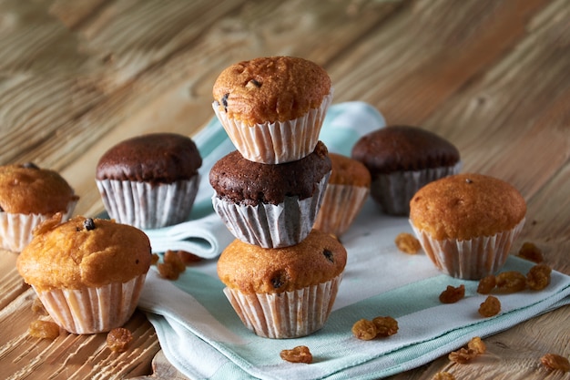 Muffin alla vaniglia e del cioccolato con i dadi su superficie di legno, fuoco selettivo