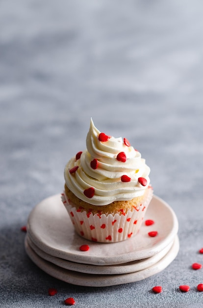 Muffin alla vaniglia su piatti e un panno bianco su sfondo grigio