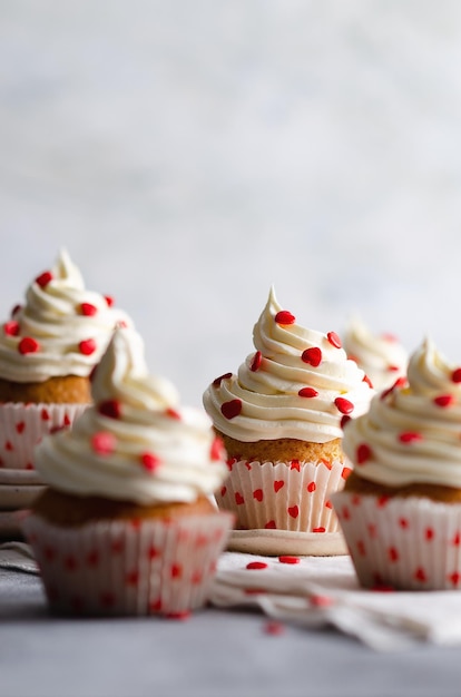 Muffin alla vaniglia su piatti e un panno bianco su sfondo grigio